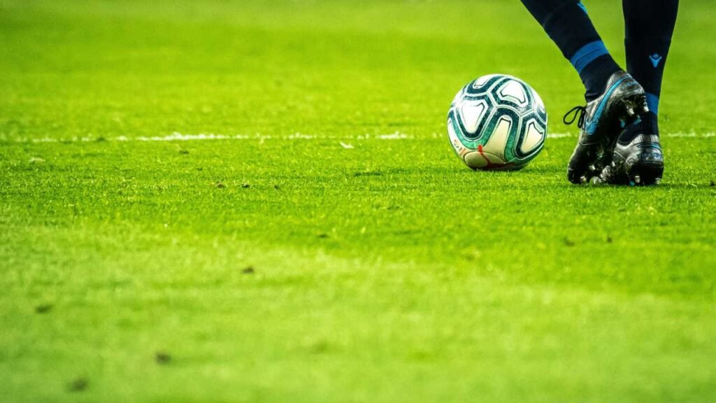 Vemos en la cancha la pelota y los pies del jugador iniciando el juego